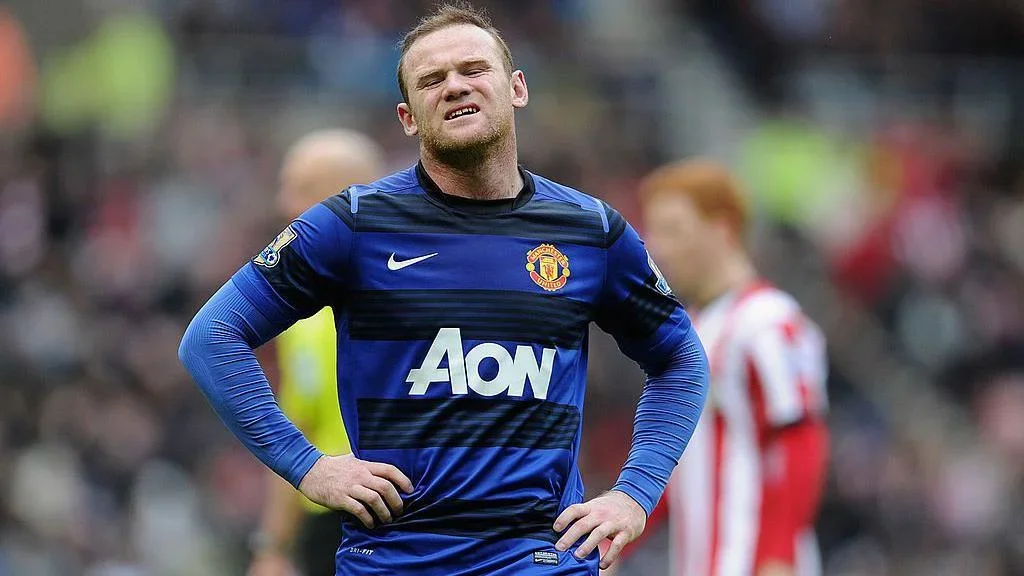 Wayne Rooney grimaces with his hands on his hips